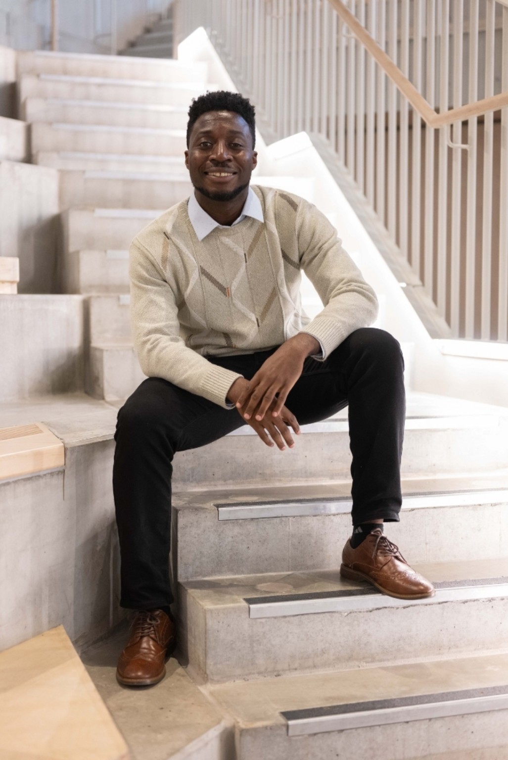Michael C. Eze seated in a cream sweater